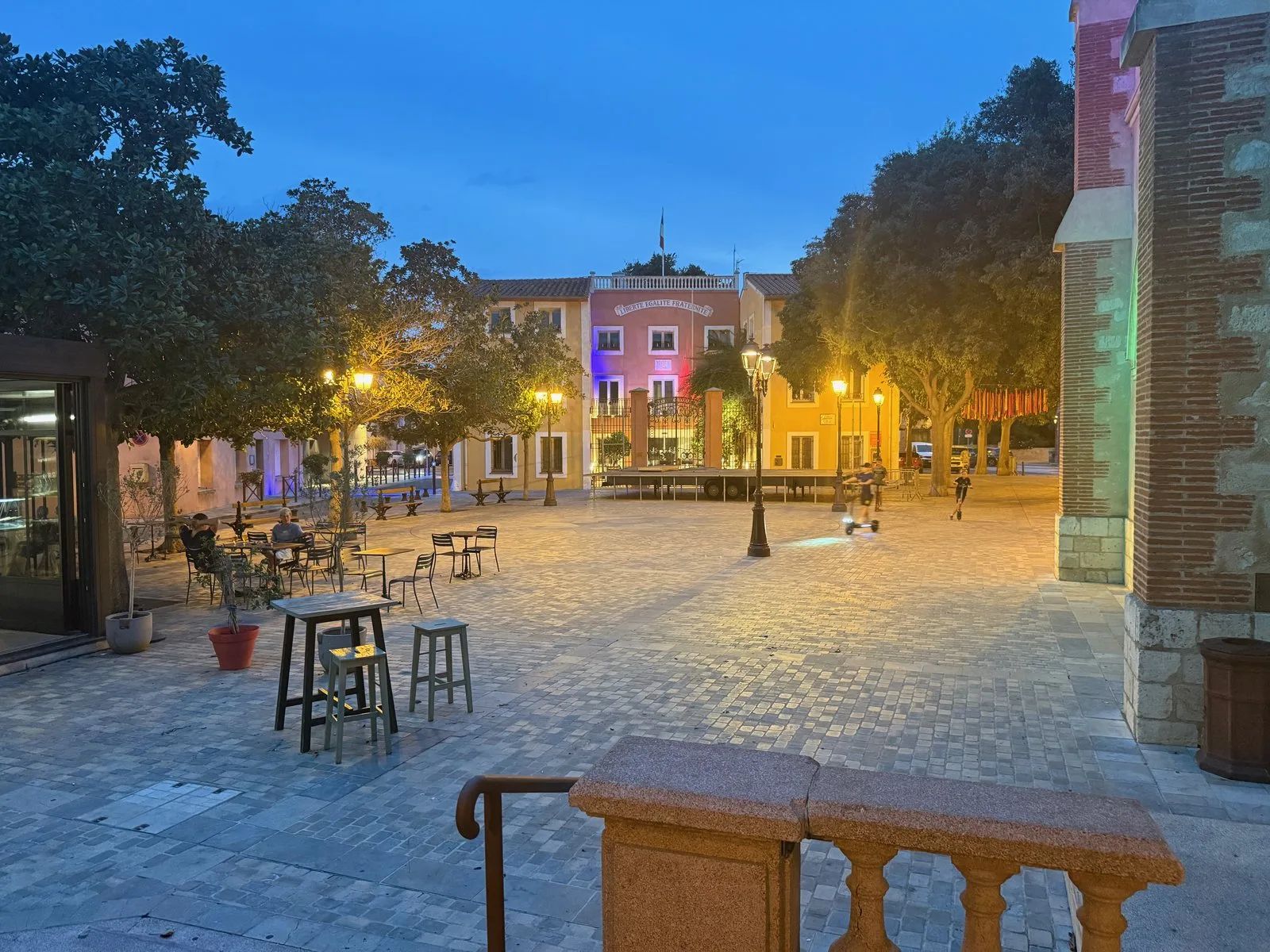 The village square of Sainte-Marie-la-Mer in the evening, with the town hall lit up